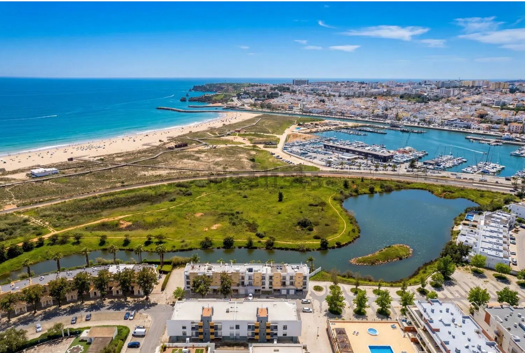 Aerial view over Meia Praia, the Marina de Lagos and the old town, with the lagoon and apartments in the foreground