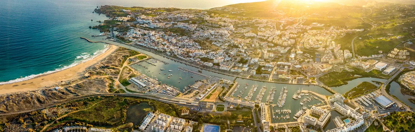 Aerial panorama of the Marina de Lagos, the beach and the old town at golden hour